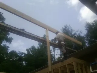 Carpenter setting a ridge beam over a new addition frame — Ice Dam Removal by Roofing Brothers in College Grove