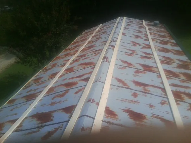 Rusted metal roof panels with new wood purlins before replacement — Storm Damage Roof Repair in College Grove by Roofing Brothers