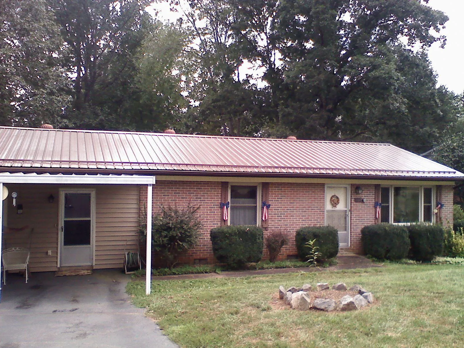 Bronze metal roof and carport on a brick ranch home — Roof Repair work by our crew in College Grove